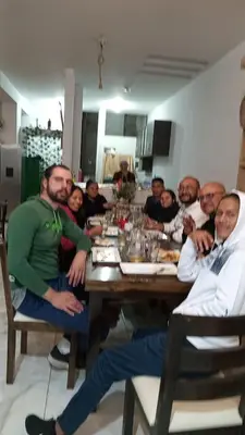 a group of people sitting around a wooden table at Hotel Sucre in Quinua