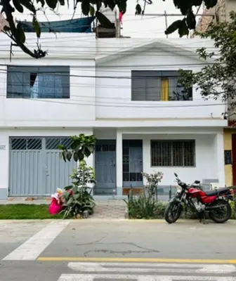 two motorcycles parked in front of a white building at Habitacion amplia cerca al aeropuerto in Lima