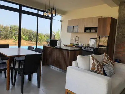 a kitchen and living room with a couch and a table at Casa de Campo La Martina con piscina y parrilla in Tambo de Mora