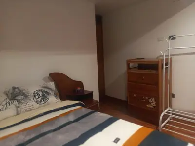 a bedroom with a bed and a wooden dresser at Habitación en Cusco in Cusco