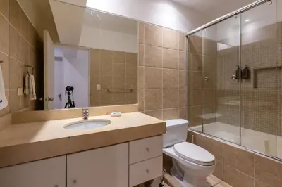 a bathroom with a toilet and a sink and a shower at Lumiere 1BR by Geko in Lima