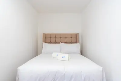 a white bed with a box on top of it at Montclair 2BR by Geko in Lima
