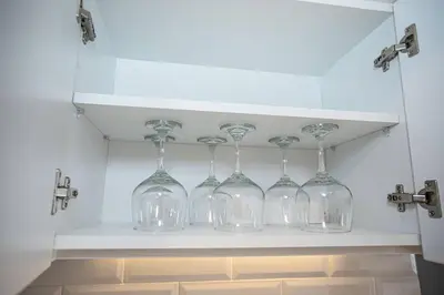 a row of wine glasses on a shelf in a kitchen at BSR Modern Spacious New Flat in Miraflores w/ Pool in Lima