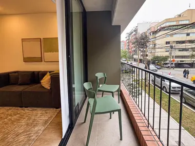 a balcony with a green chair and a couch at New 2D gym-grill Miraflores 1 block Malecón in Lima
