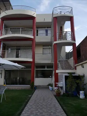 an apartment building with two balconies and a patio at Casa de Campo en el Valle Sagrado de los Incas - Casa Brisas del Rio Sagrado in Huayllabamba