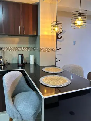 a kitchen with a black counter with two chairs at Apartamento Lucky House Cusco in Cusco