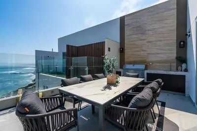 a dining room with a table and chairs on a balcony at The Sight by Geko in Lima
