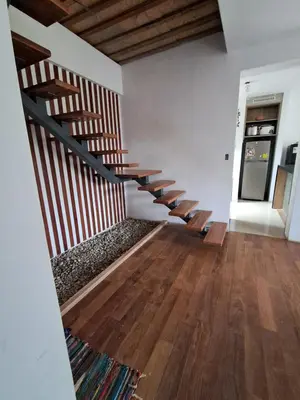 a staircase in a living room with wooden floors at BellaVista Hospedaje Casa completa, cocina y terraza in Oxapampa