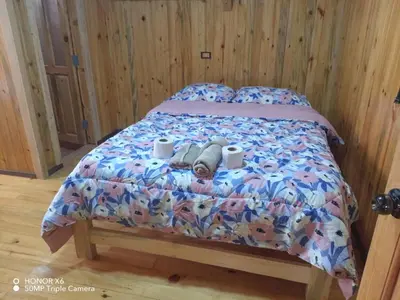 a bed with two towels and two cups on it at Cabaña VALLE ENCANTADO