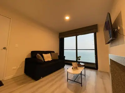 a living room with a couch and a large window at Departamento con baño y cocina equipada in Lima
