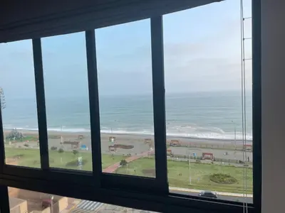 a view of the ocean from a window at Departamento con baño y cocina equipada in Lima