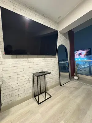 a room with a large flat screen tv on a brick wall at Acogedor Loft con ubicación céntrica en Lima in San Antonio