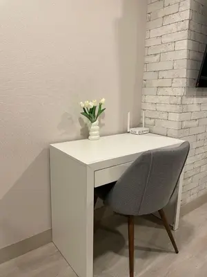 a white desk with a vase of flowers and a chair at Acogedor Loft con ubicación céntrica en Lima in San Antonio