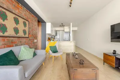 a living room with a couch and a brick wall at Miraflores - departamento con 3 dormitorios in Lima