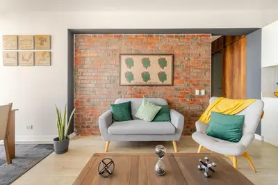 a living room with a couch and a brick wall at Miraflores - departamento con 3 dormitorios in Lima