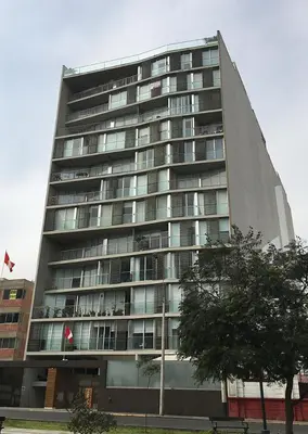 a large building with windows and a tree in front of it at Miraflores - departamento con 3 dormitorios in Lima