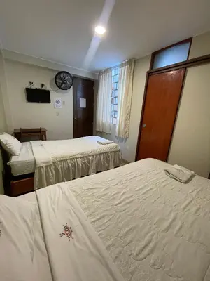 a hotel room with two beds and a window at Misky Illari Hospedaje in Ica