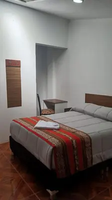 a bedroom with a large bed in a room with a table at Refugio Sagrado Boutique in Cusco