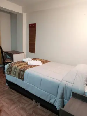 a bedroom with a bed and a table and a desk at Refugio Sagrado Boutique in Cusco