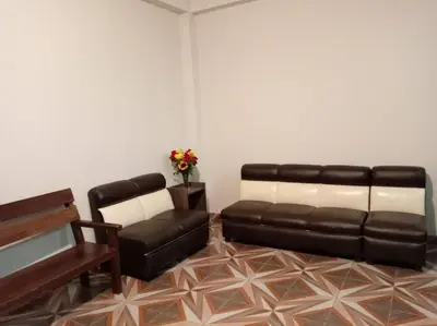 a living room with a leather couch and a piano at Refugio Sagrado Boutique in Cusco