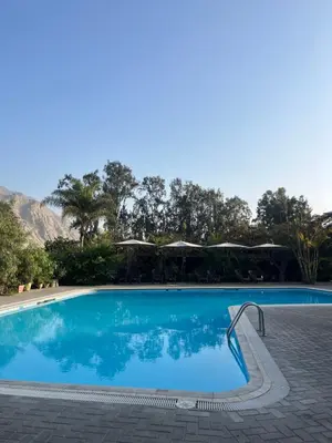 a blue swimming pool with a stairway leading into it at Rosa Estela in Cieneguilla