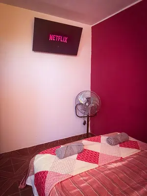 a bedroom with a bed with a red wall at Hospedaje Arco Real in Ica