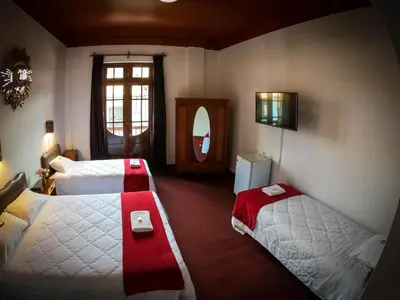 a hotel room with two beds and a window at Casona Santa Catalina Cusco in Cusco