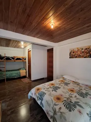 a bedroom with a bed and a wooden ceiling at BellaVista 2 habitaciones con balcón in Oxapampa