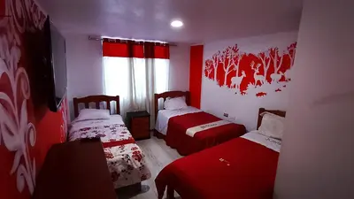 a red room with two beds and a window at Hotel D'Gloria Churin in Churín