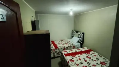 a small room with two beds in it with a bedskirts at Hotel D'Gloria Churin in Churín