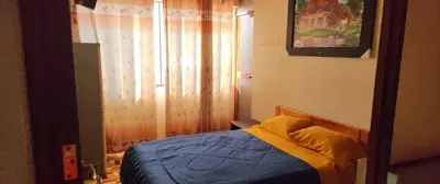 a bedroom with a bed with blue sheets and a window at Hostal Casa Blanca in Ayacucho