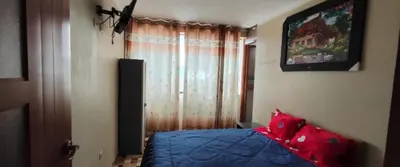 a bedroom with a blue bed and a window at Hostal Casa Blanca in Ayacucho