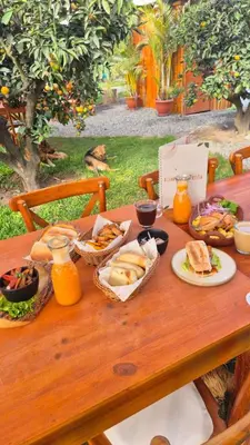 a wooden table with sandwiches and baskets of food on it at Mandarhemia Club in Huaral