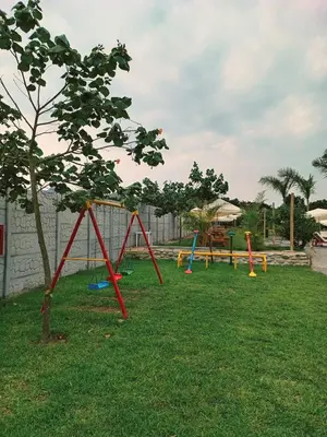 a playground with colorful swings in the grass at Mandarhemia Club in Huaral