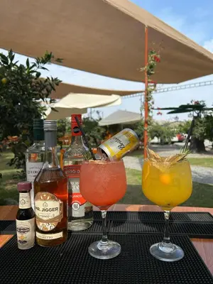 three drinks on a table with bottles of alcohol at Mandarhemia Club in Huaral