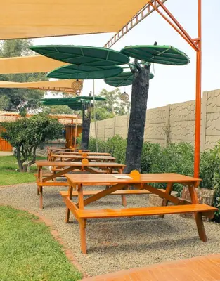 a row of picnic tables with green umbrellas at Mandarhemia Club in Huaral