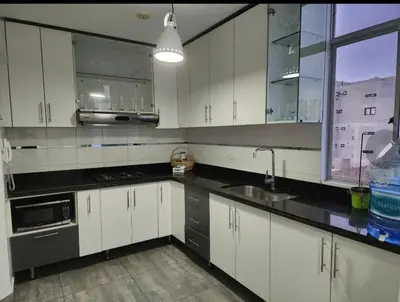 a kitchen with white cabinets and a sink and a window at barranco apartament R&M in Lima