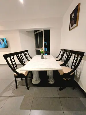 a table with two chairs and a white table cloth on it at barranco apartament R&M in Lima