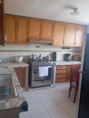 a kitchen with wooden cabinets and a stove top oven at Duplex en San Borja in Lima