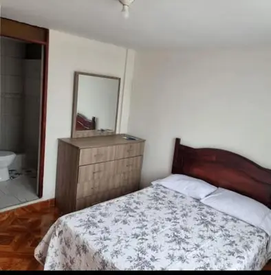 a bedroom with a bed and a sink and a mirror at Duplex en San Borja in Lima