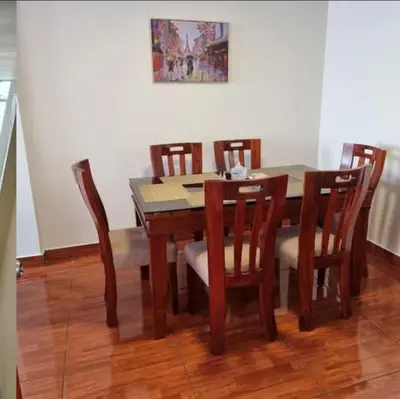 a dining room table with chairs and a table and a painting at Duplex en San Borja in Lima