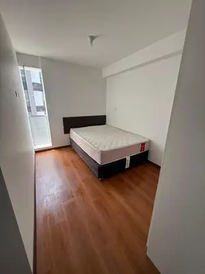 a bedroom with a bed and a wooden floor at Departamento San Sebastian in Lima
