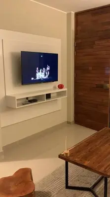 a living room with a television on a wall at CASA DUNE Acogedora casa a 7 minutos Huacachina in Ica