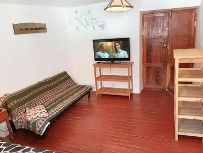 a living room with a couch and a tv on the wall at Gatanas House in Cusco