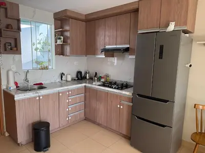 a kitchen with wooden cabinets and a stainless steel refrigerator at Ethan's House - Como en Casa