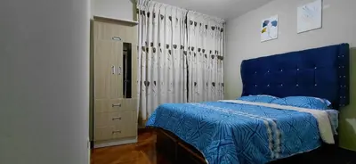 a bedroom with a blue bed and a dresser at Depa Amoblado en Villa María, Excelente ubicación, WiFi, y Parking in Villa María del Trunfo