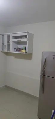 a kitchen with a refrigerator and a white wall at Depa Amoblado en Villa María, Excelente ubicación, WiFi, y Parking in Villa María del Trunfo