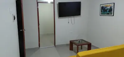 a living room with a yellow couch and a tv at Depa Amoblado en Villa María, Excelente ubicación, WiFi, y Parking in Villa María del Trunfo