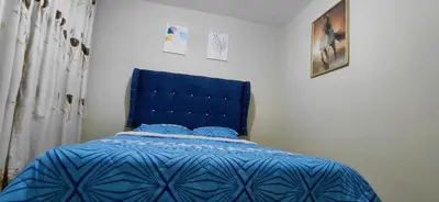 a bed with a blue headboard in a bedroom at Depa Amoblado en Villa María, Excelente ubicación, WiFi, y Parking in Villa María del Trunfo