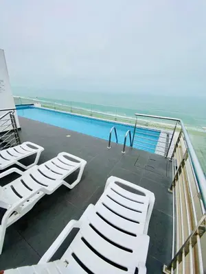 a group of white chairs sitting next to a swimming pool at San Miguel Apartment Vista Mar in Lima